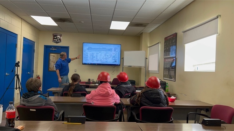 Students listened to Fred Ensley discuss blue prints fir the barges. 